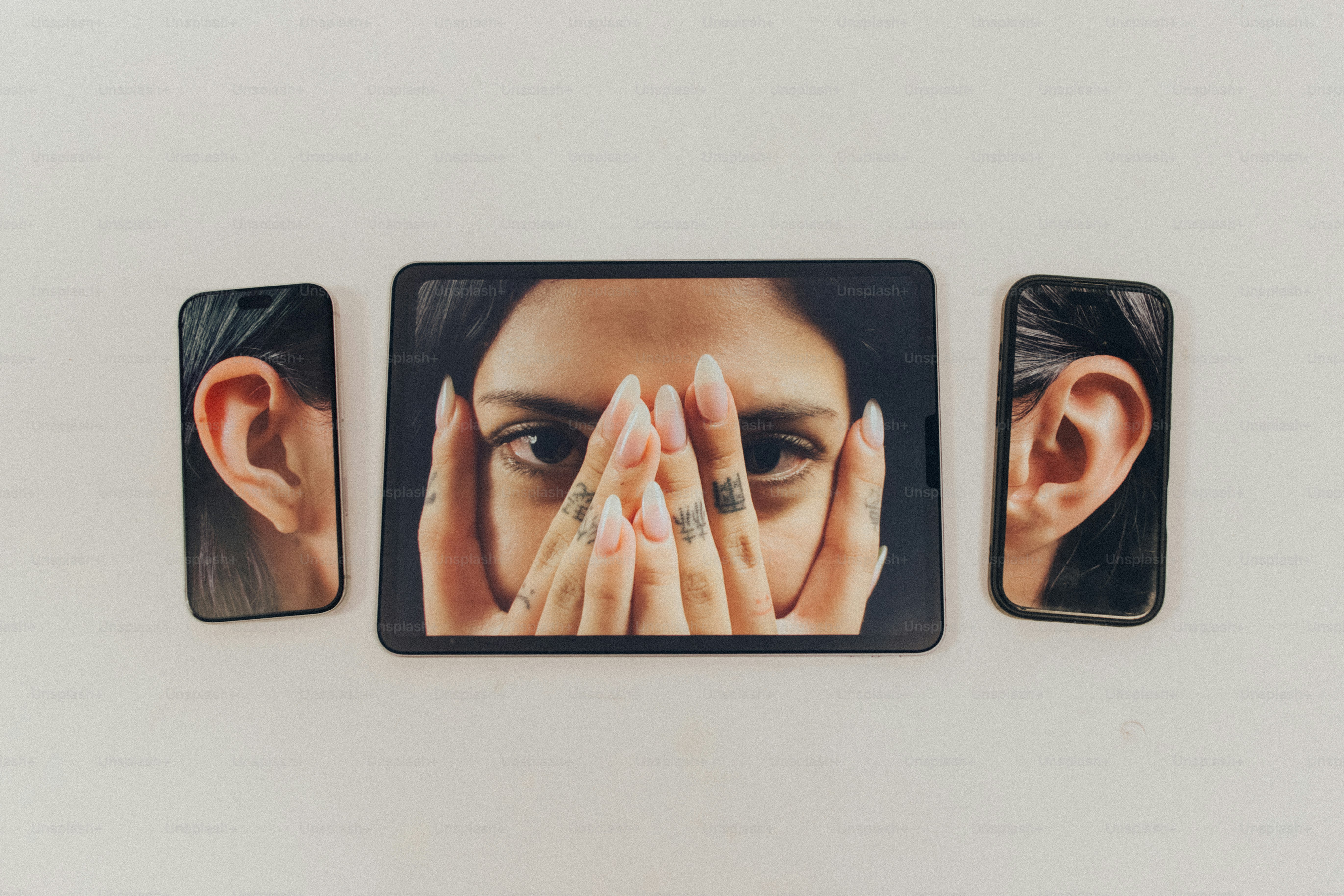 Smartphones displaying face halves - Photo on Unsplash+