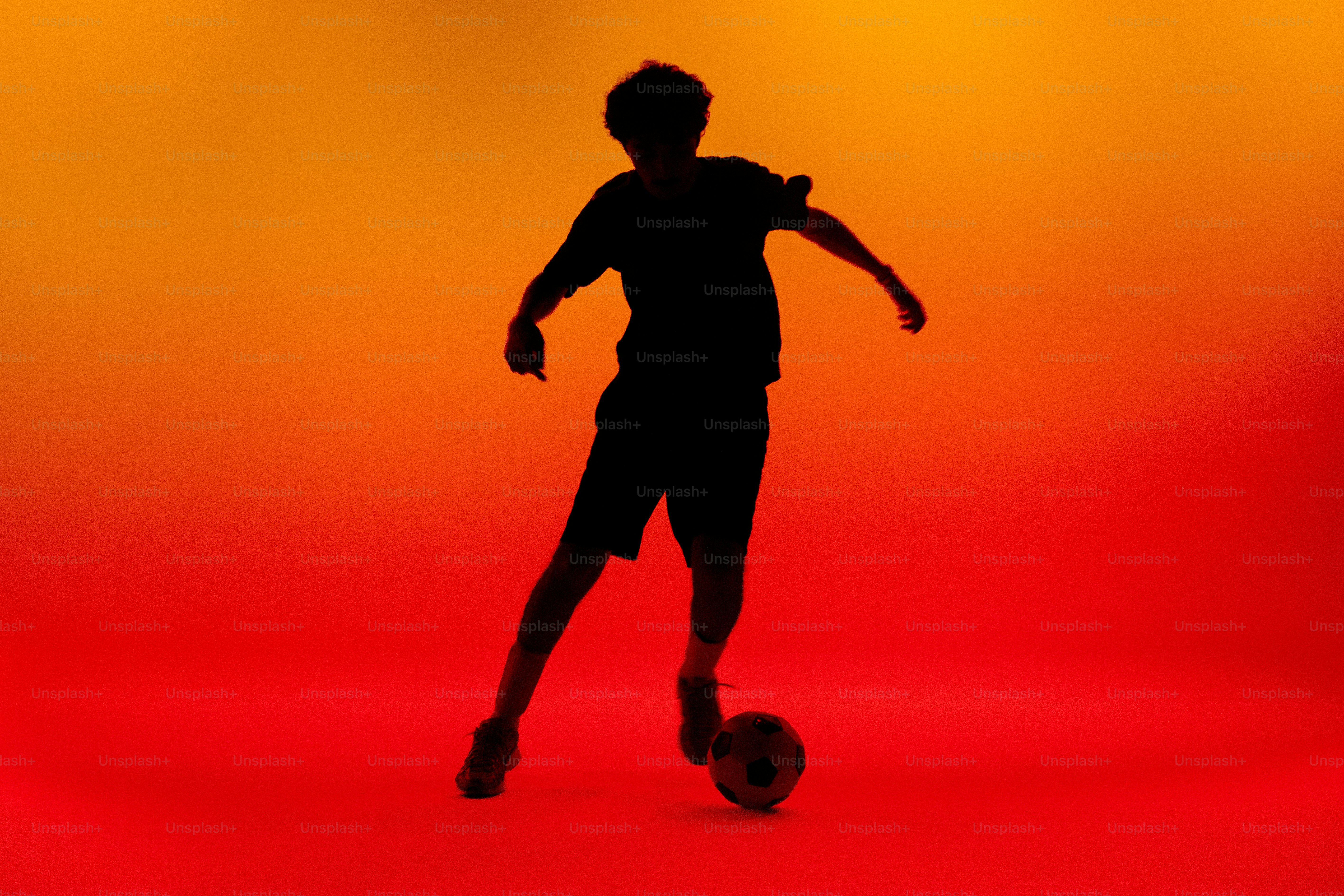 Person juggling soccer ball in silhouette - Photo on Unsplash+