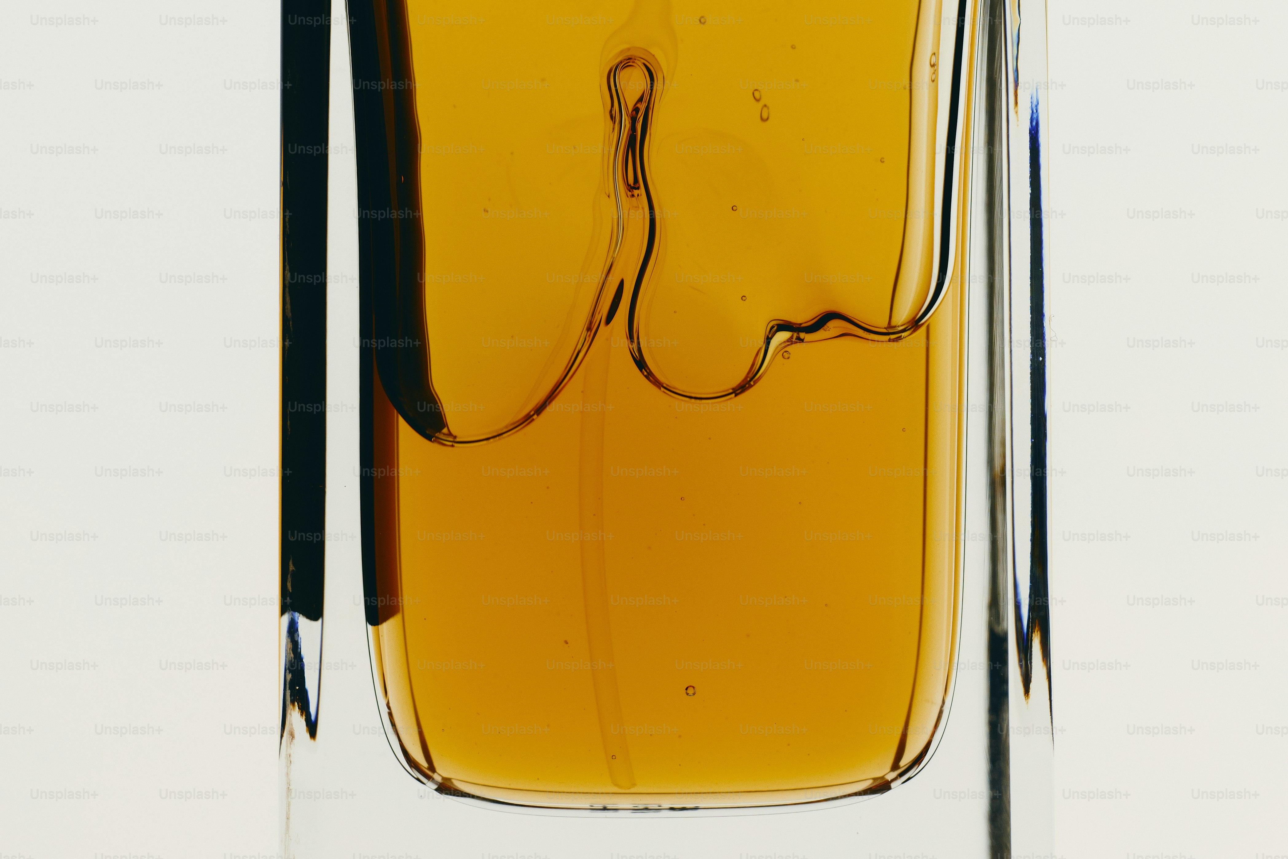 Amber liquid in glass bottle - Photo on Unsplash+