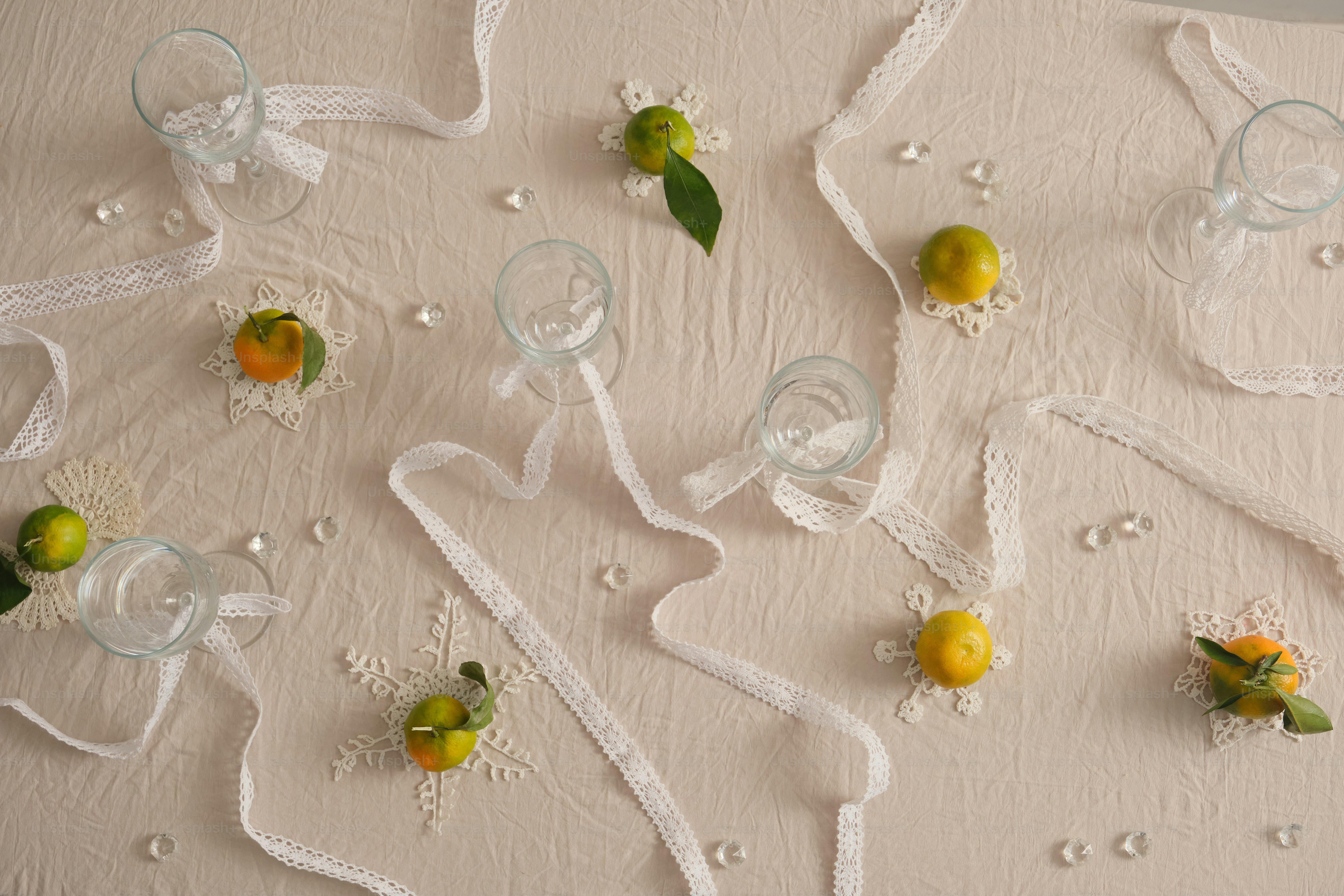 Citrus fruits and lace on tablecloth - Photo on Unsplash+