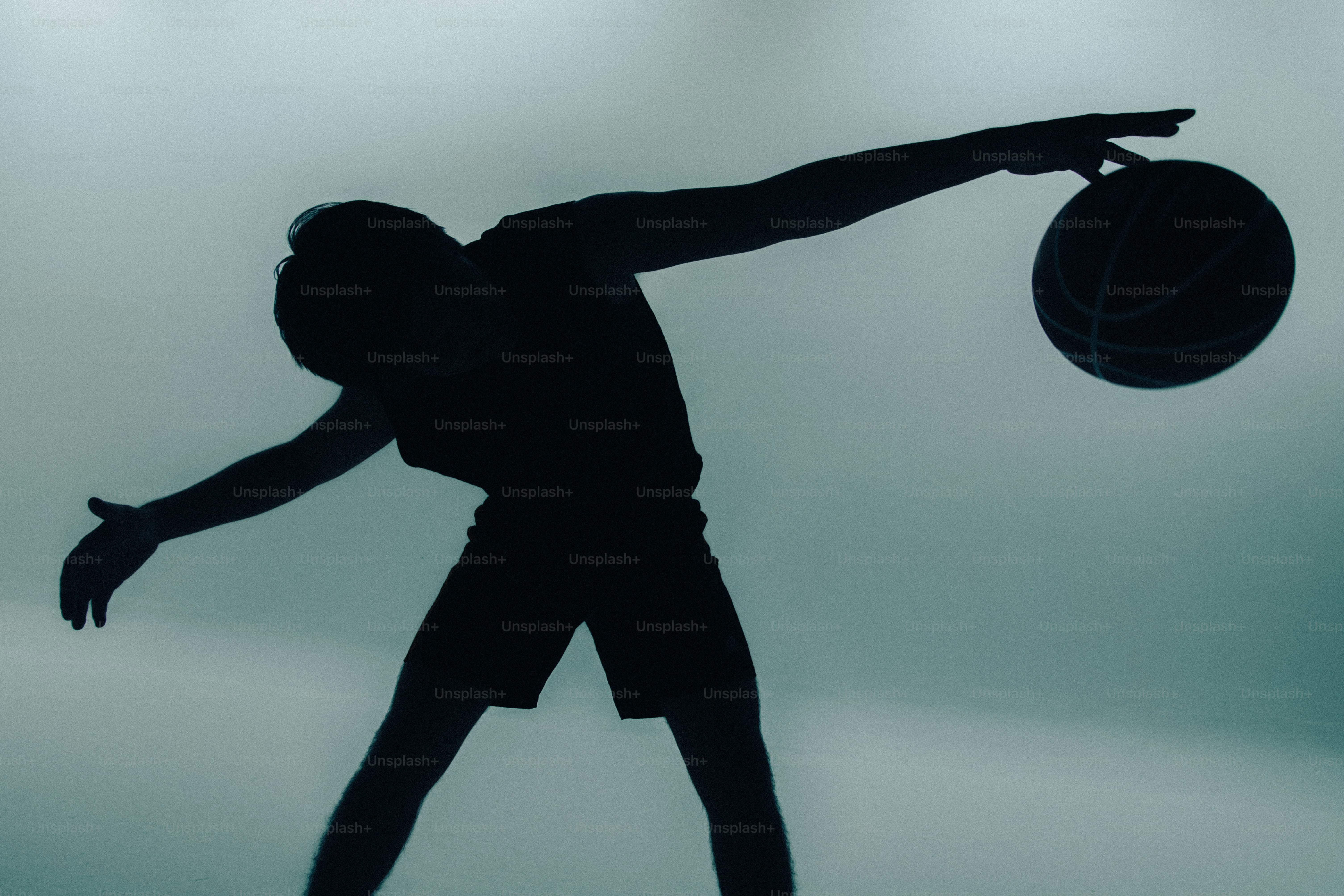 Silhouette of person balancing basketball - Photo on Unsplash+