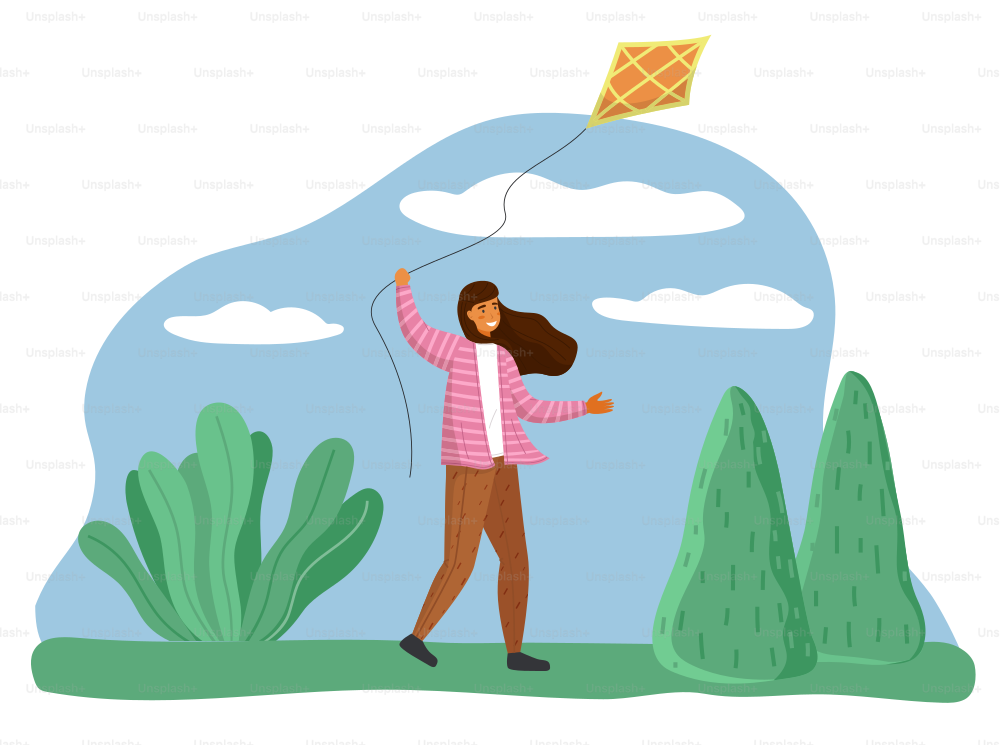 Smiling happy girl in park playing with kite flying in air in the wind. Child running holding thread in hand. Character with paper kite on background of green plants on grass and blue sky with clouds