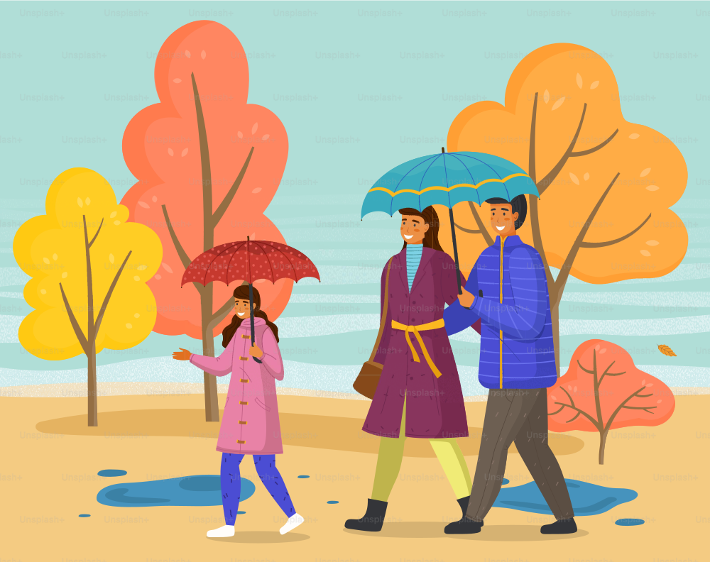 Parents and daughter spend time together on a rainy october day go down the street past yellow trees. Family walking in the rain with umbrella and wearing raincoats in the city park in autumn season.