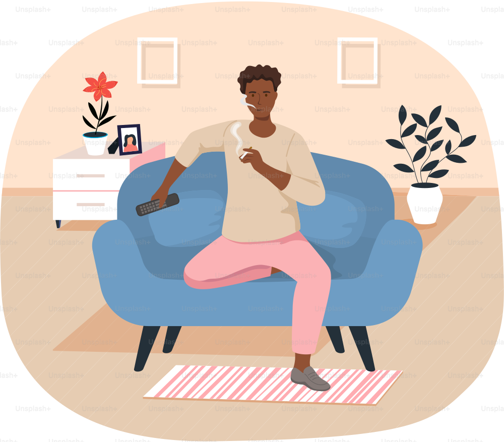 African man with TV remote is smoking cigarette in living room. Tobacco dependence. Unhealthy lifestyle and bad habits concept. Guy with cigarette in his hands is relaxing in apartment alone
