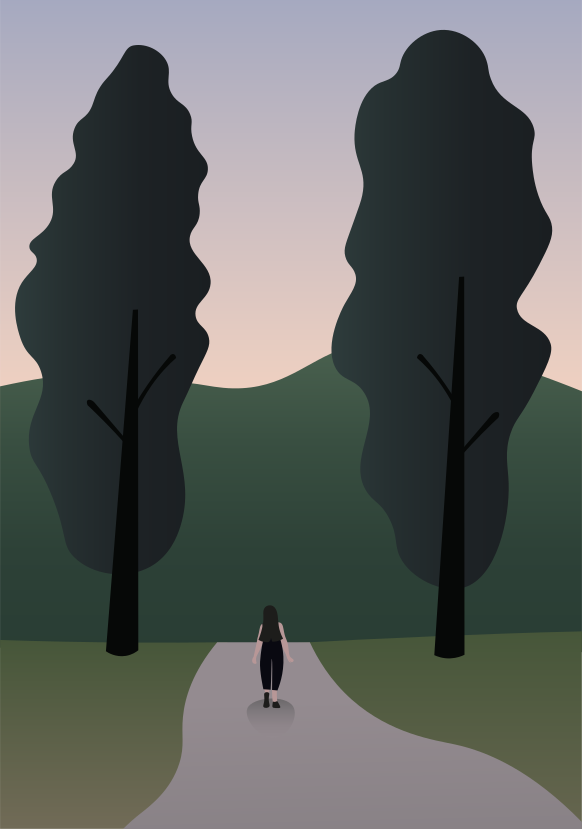 A person walking down a road in the middle of a forest