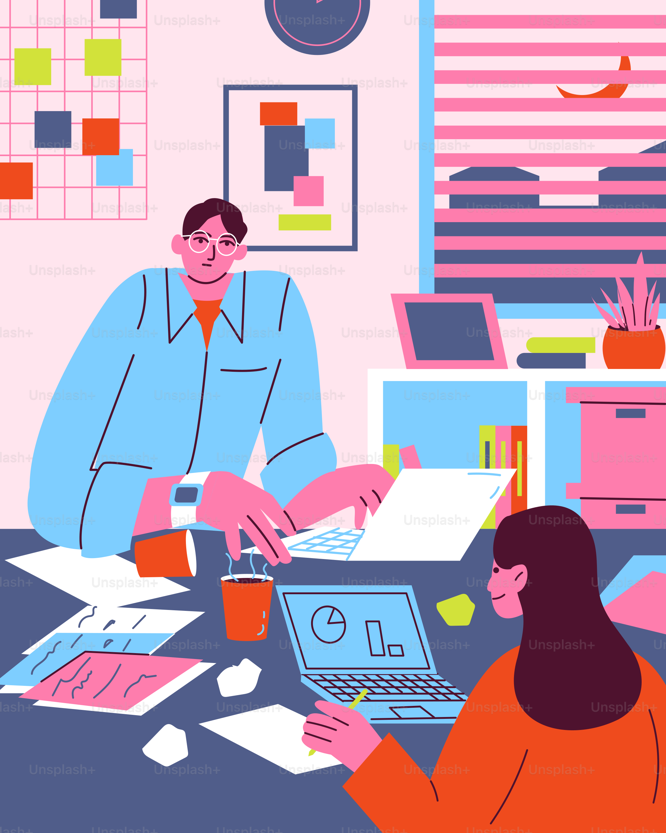 A man and a woman sitting at a table working on laptops