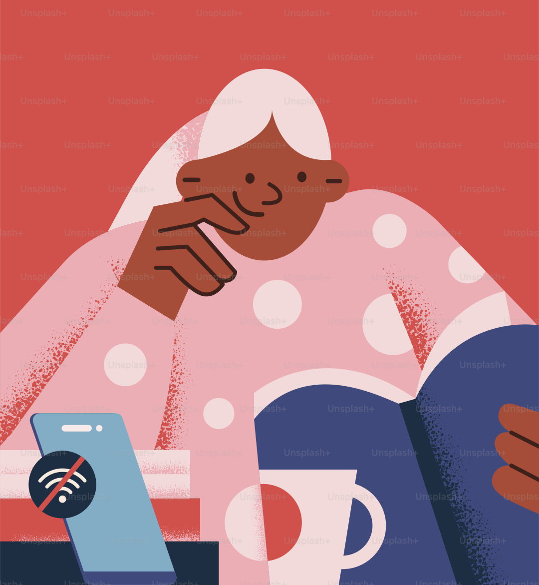 Eine Frau, die mit einem Buch und einem Handy an einem Tisch sitzt