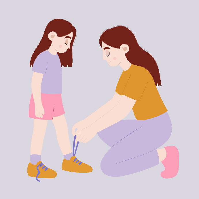 母親が娘の靴ひもを結んでいる。