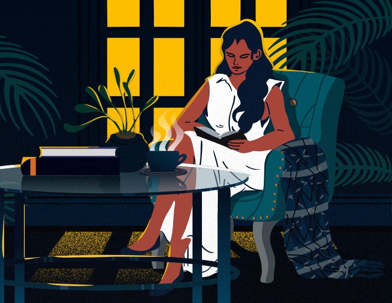 A woman reads comfortably in a dimly lit room.