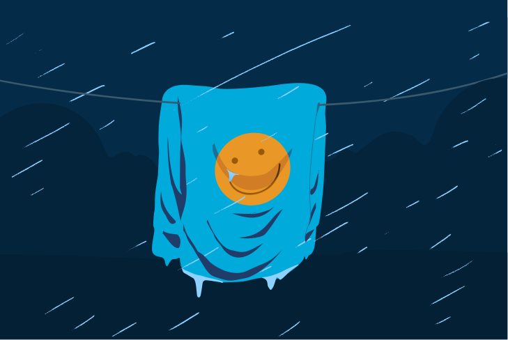 A towel with a smiley face dries in the rain.