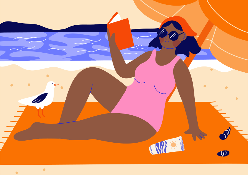 Uma mulher lê um livro na praia.