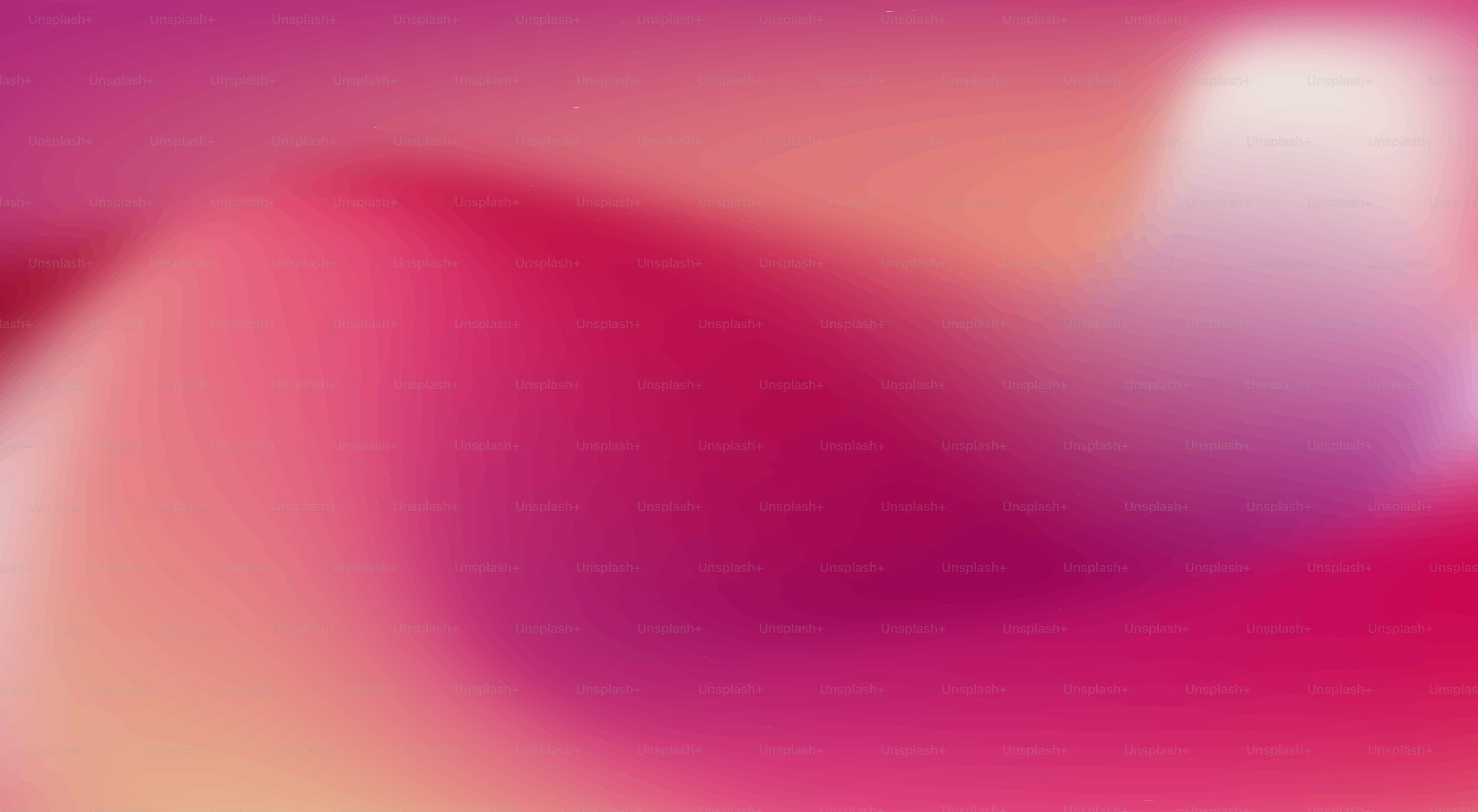 A soft, gradient background of pink and red hues.