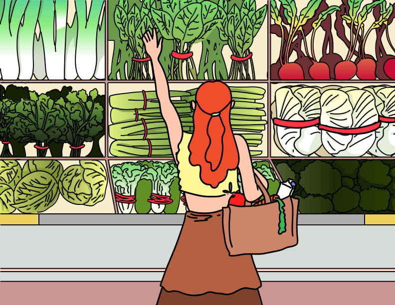 A woman reaches for fresh greens in the store.