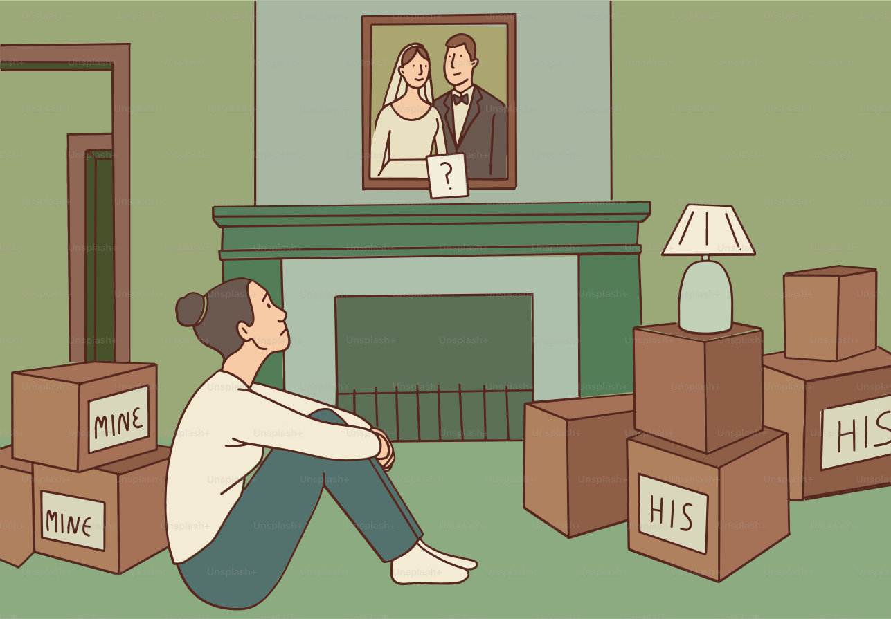 Eine Frau sitzt zwischen Umzugskisten und betrachtet das gerahmte Foto.