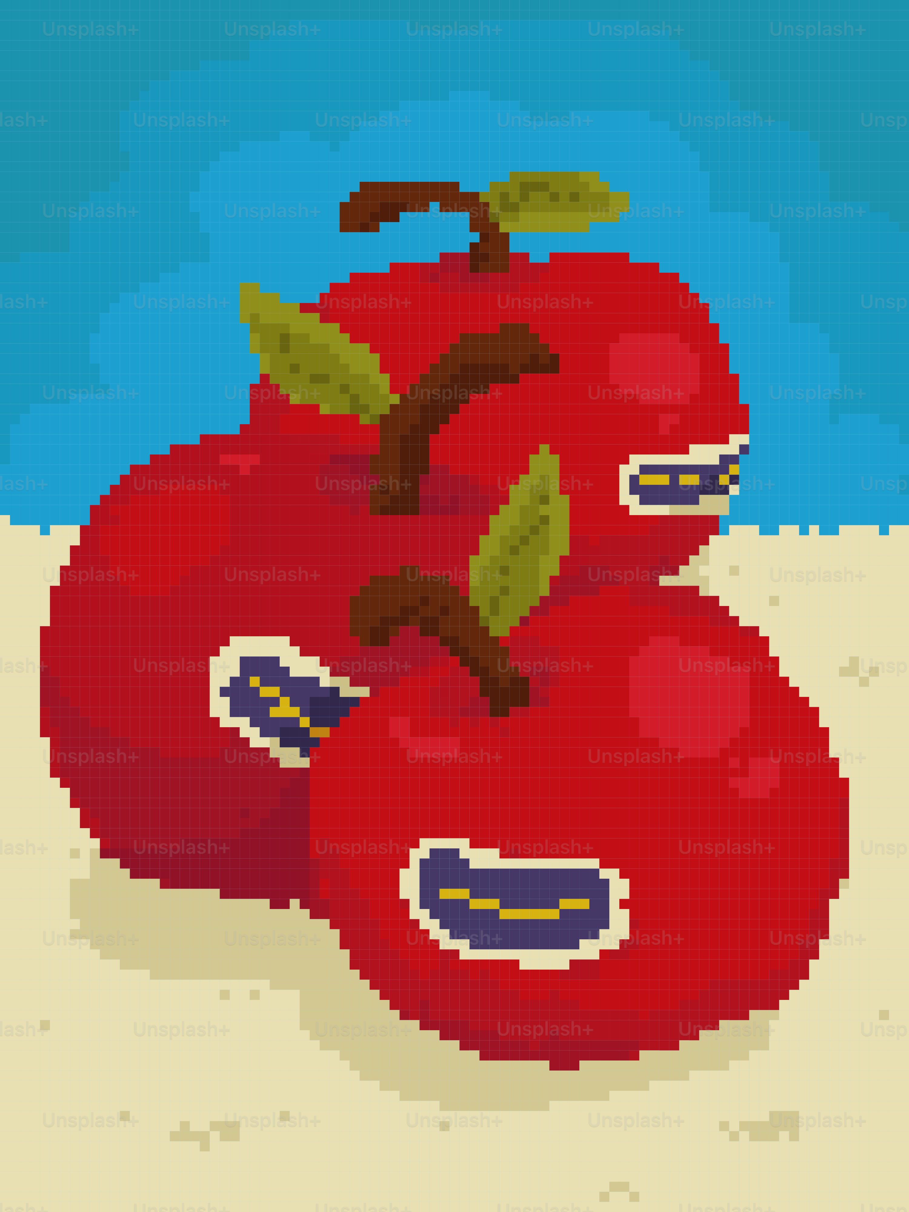 Three red apples with stickers on sand