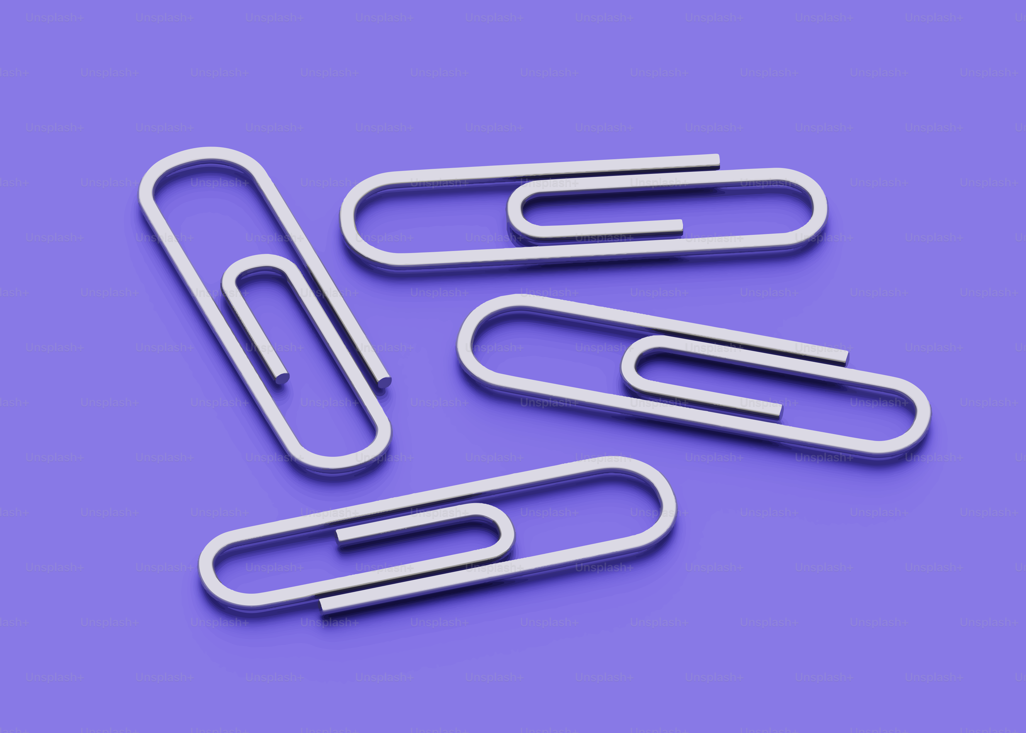 Four silver paperclips on a purple background