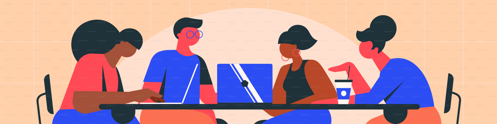 Vier Personen sitzen um einen Tisch mit Laptops.