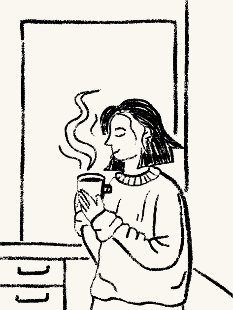 Woman holding a steaming mug with eyes closed