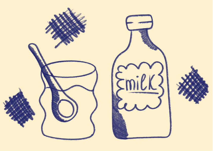 A bottle of milk and a glass with a spoon.