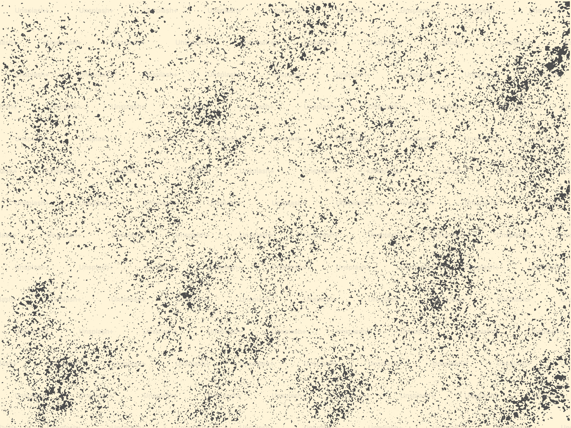 Texturierter beiger Hintergrund mit dunklen Sprenkeln.