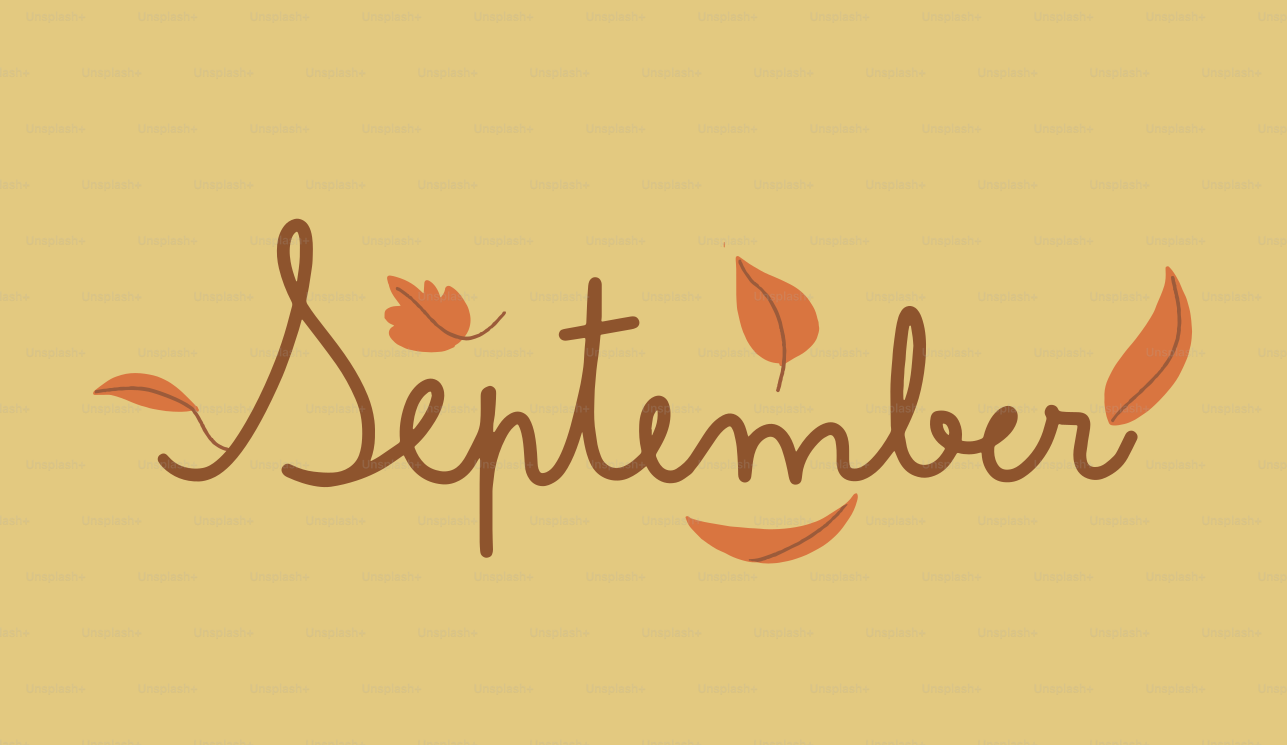 The word september with falling autumn leaves.