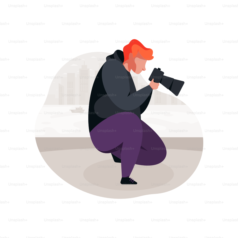 Man with red hair crouching with a camera.