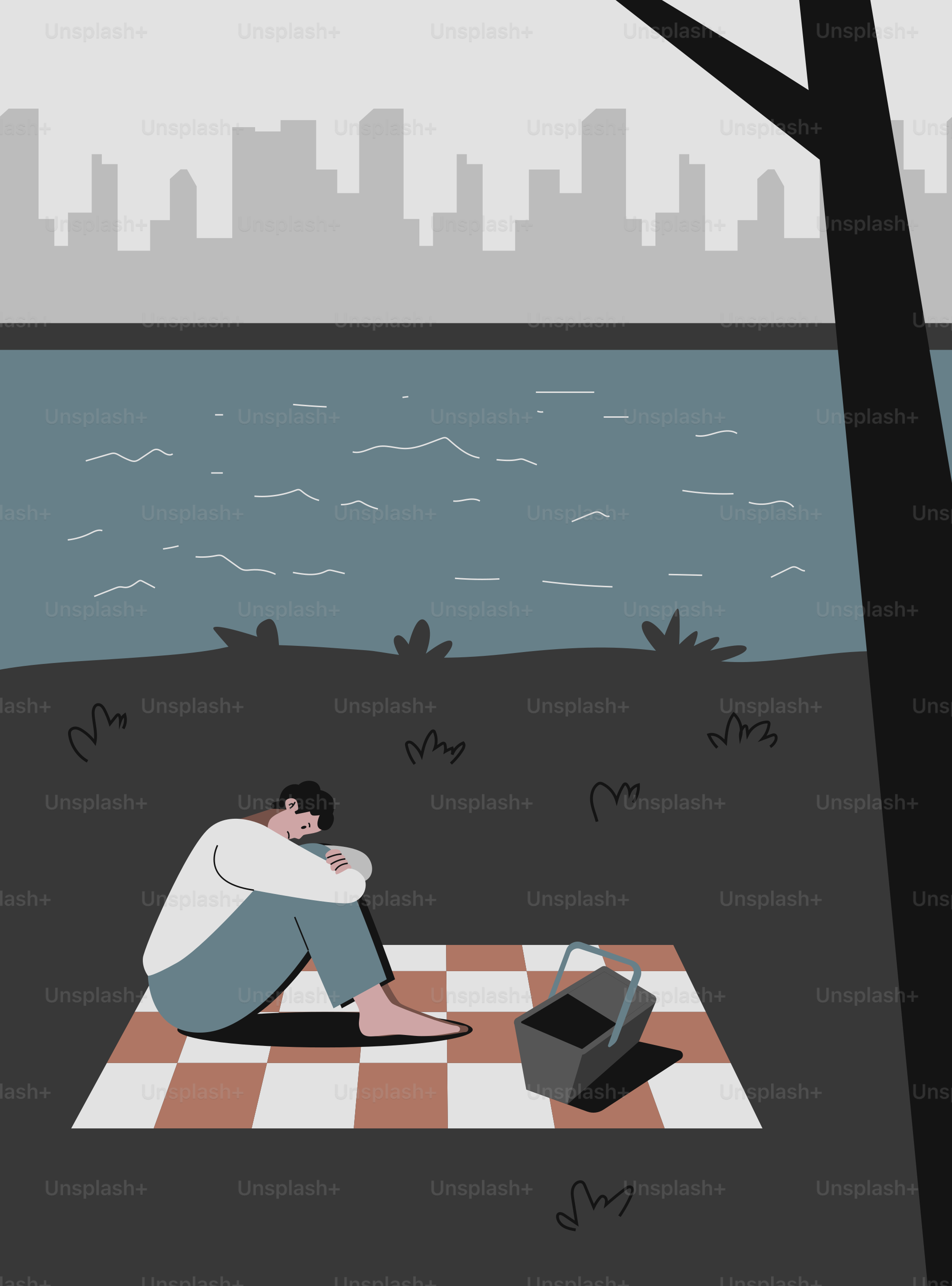 水辺のピクニックブランケットに一人で座る男