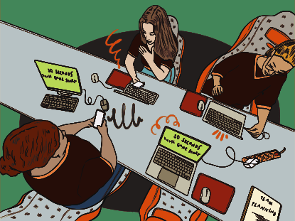People working at a long table with computers.