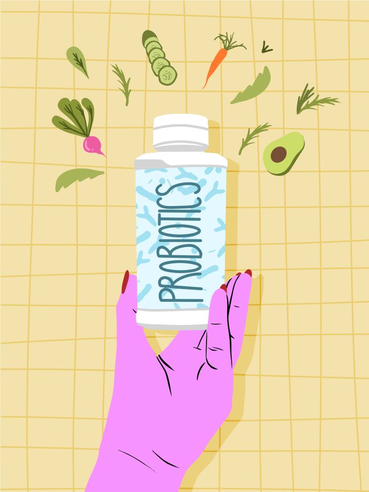 Segure a mão com o frasco de probióticos com vegetais frescos ao redor.