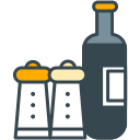 Two salt and pepper shakers next to a dark bottle.