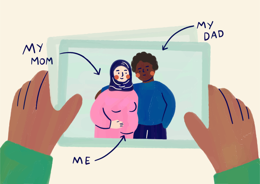 Hands holding a picture of a pregnant person and a partner