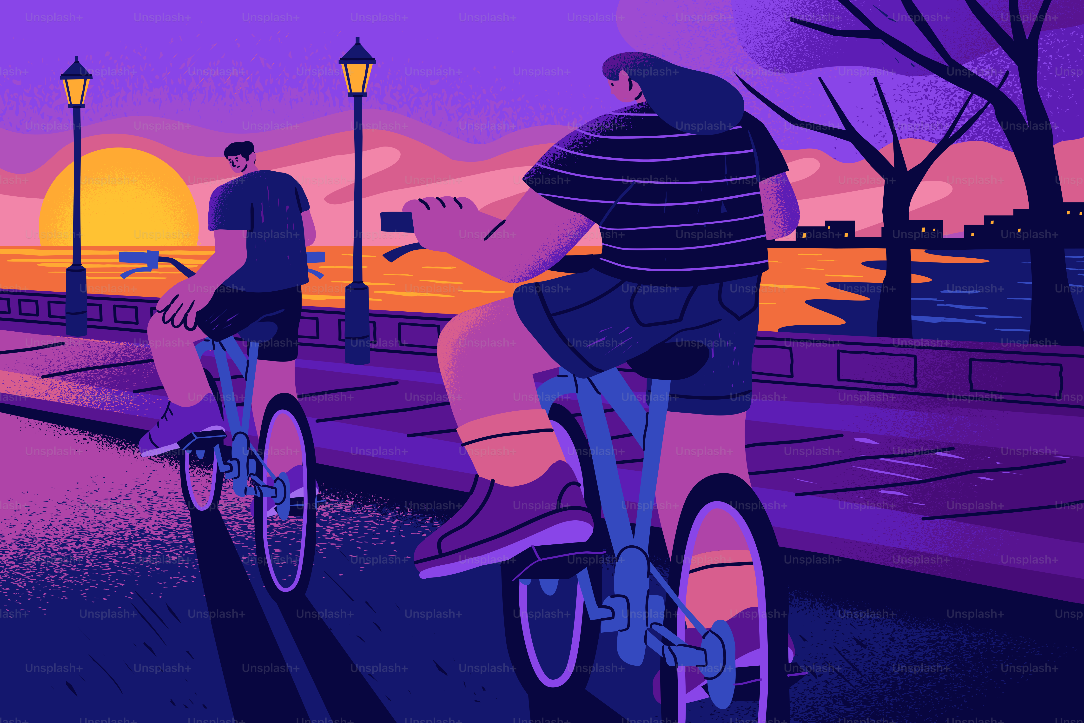 Two people cycling on a path by the water during a warm evening