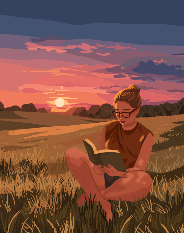 A woman with glasses reading a book in a grassy field at golden hour